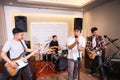 four young men as a band sing songs and play musical instruments during sound check Royalty Free Stock Photo