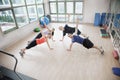 Four young people stretching and looking at the camera in an aerobics class