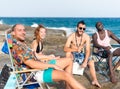 four young people sunbathing on a rocky beach Royalty Free Stock Photo