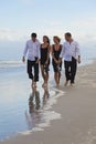 Four Young People, Two Couples, Walking On A Beach Royalty Free Stock Photo