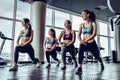 Four young sporty girl with athletic body doing fallouts in gym.