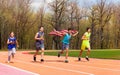 Four young sprinters waving American flag on track