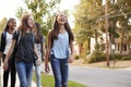 Four young teen girls walking to school, front view close up