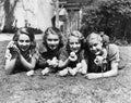 Four young women lying outside with baby chicks. Royalty Free Stock Photo