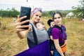 FourE ethnic festival, two babywearing mothers making selfie with slleping in babycarrier children Royalty Free Stock Photo