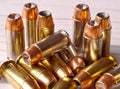 Fourteen different 40 caliber hollow point bullets together on a white wooden background