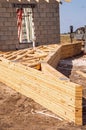 Fourteen wood trusses, stacked up, on ground