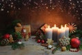 Fourth Advent, four candles are lighted, Christmas decoration and gifts on rustic wooden planks against a dark brown background