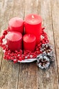 Four candles in a white wreath with red berries on a wooden rustic background with lights. advent calendar for Christmas Royalty Free Stock Photo