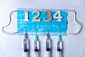 Fourth covid vaccine shot and jab concept with face mask. Four syringes are seen on table as a concept for the 4th covid-19 Royalty Free Stock Photo