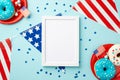 Fourth of July concept. Top view photo of photo frame national flag garland confetti plates with donuts and candies on isolated