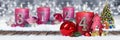 fourth sunday of advent red candle with golden metal number one on wooden planks in snow front of silver bokeh background Royalty Free Stock Photo