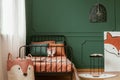 Fox kid bedroom interior with molding on green wall and orange sheets on the bed. Real photo Royalty Free Stock Photo