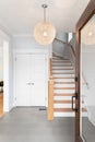 A foyer with a wood door and hanging light.