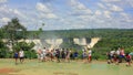 Tourists looking to blurred from splashes cascades of Iguazu Falls,Brazilian side