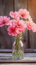 Fragile beauty Pink flowers in a glass vase on wood