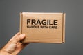 Fragile handle with care cardboard box in male hand isolated Royalty Free Stock Photo