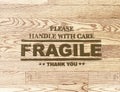 Fragile word stamp on wood plank background Royalty Free Stock Photo