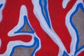 Fragment of an abstract background of red and blue graffiti on a concrete wall