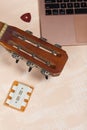 Fragment of acoustic guitar and notebook. Nearby there is a tuning fork and a pick. Against a background painted in white and Royalty Free Stock Photo