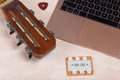 Fragment of acoustic guitar and notebook. Nearby there is a tuning fork and a pick. Against a background painted in white and Royalty Free Stock Photo