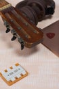 Fragment of acoustic guitar and notebook. Nearby are wireless headphones, a tuning fork and a pick. Against a background painted Royalty Free Stock Photo