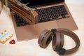 Fragment of acoustic guitar and notebook. Nearby are wireless headphones, a tuning fork and a pick. Against a background painted Royalty Free Stock Photo