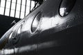 Fragment of the aircraft fuselage with rivets and portholes in the hangar Royalty Free Stock Photo