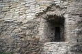 Fragment of ancient crumbling limestone fortress wall with embrasure Royalty Free Stock Photo