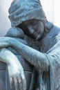 Fragment of an ancient iron statue of sad and desperate woman on tomb as a symbol of death and the end of human life. Verticaal Royalty Free Stock Photo