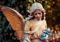 A fragment of ancient sculpture angel in a golden glow in the old cemetery. Symbol of love, invisible forces, purity, Royalty Free Stock Photo