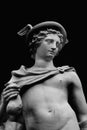 Fragment of an ancient statue of antique god of commerce, merchants and travelers Hermes (Mercury) on black background Royalty Free Stock Photo