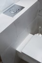 Fragment of bathroom interior: White toilet on white wall