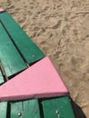 fragment of the bench pink and green in the sand