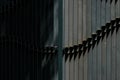 Fragment of a black fence made of strips of steel illuminated by the sun Royalty Free Stock Photo
