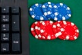 Fragment of black keyboard with gamble chips.