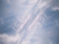 A fragment of the blue sky covered with white cirrus symmetrical clouds.