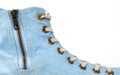 Fragment of a blue sneaker with white textile laces and an iron zipper clasp