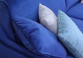 A fragment of a blue velvet sofa with three pillows.