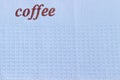 Fragment of the blue waffle towel with word coffee