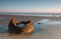 Fragment of a boulder on the ocean shore at sunrise