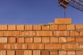 Fragment of a brick wall on a background of blue sky. Royalty Free Stock Photo
