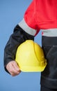 Fragment of a builder holding yellow hard hat