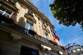 Fragment of the building facade decorated with pilasters and reliefs. Hanging flags of several countries. Boulevard des Capucines Royalty Free Stock Photo