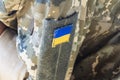 Fragment of camouflage uniform of Ukrainian soldier, close-up of the Ukrainian flag on the sleeve