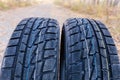 Fragment of car tires with aggressive tread on blurred background