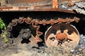 A fragment of a caterpillar of a burnt and charred tank. A blown up and burnt tank at the front. War