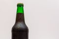 Fragment of a closed green bottle with dark beer Royalty Free Stock Photo