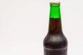 Fragment of a closed green bottle with dark beer Royalty Free Stock Photo