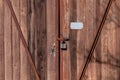 Fragment of a closed wooden gate with a sealed padlock